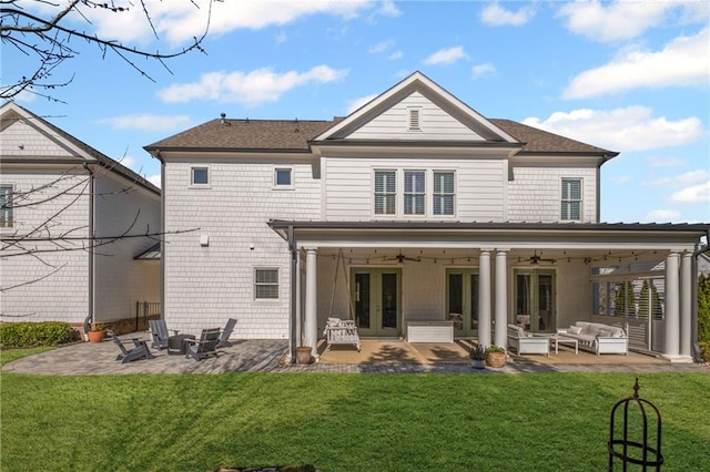 rear view of house with a yard, ceiling fan, french doors, a patio area, and an outdoor hangout area