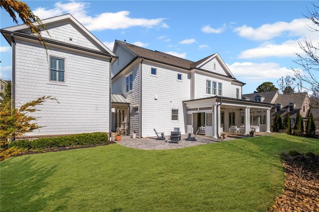 rear view of house with a yard and a patio