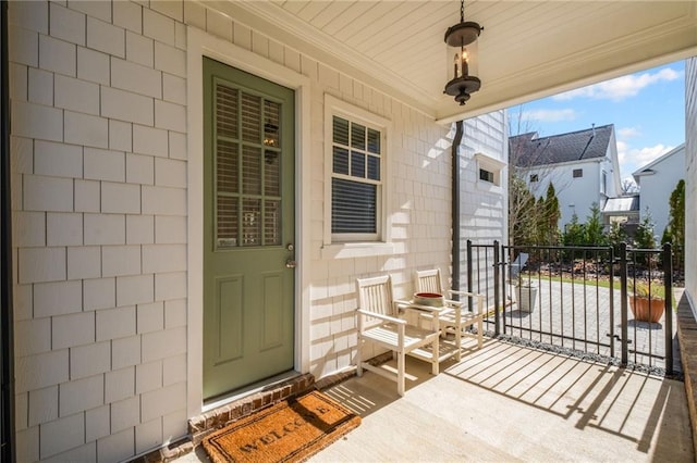 doorway to property featuring a porch and a gate