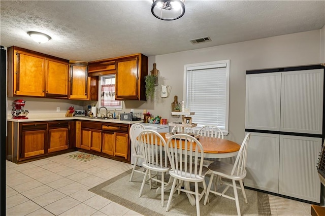 kitchen featuring light tile patterned flooring, sink, and a textured ceiling