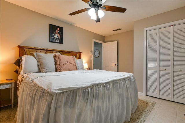 bedroom with ceiling fan, a closet, and light tile patterned floors