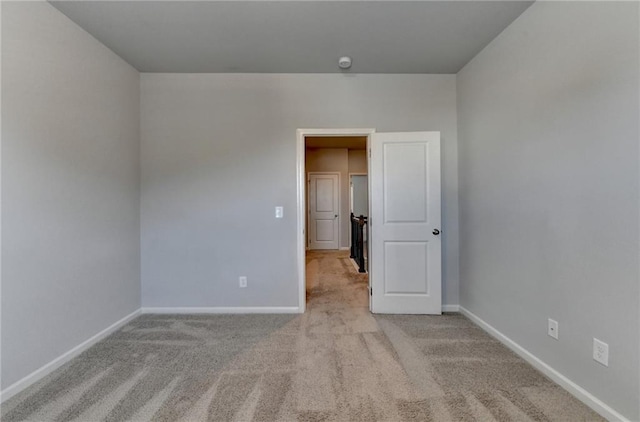 spare room with baseboards and carpet flooring