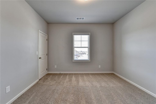 carpeted empty room featuring visible vents and baseboards