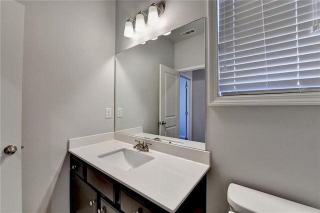 bathroom featuring toilet, visible vents, and vanity