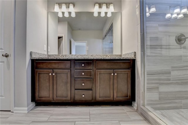 bathroom featuring double vanity and a tile shower