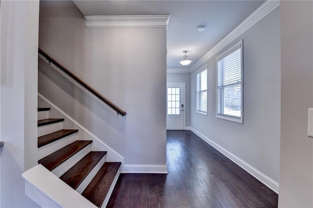 foyer entrance featuring ornamental molding, stairway, wood finished floors, and baseboards