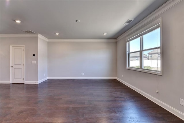 spare room with ornamental molding, dark wood-style flooring, visible vents, and baseboards