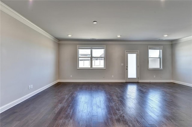 spare room featuring crown molding, baseboards, and dark wood-type flooring