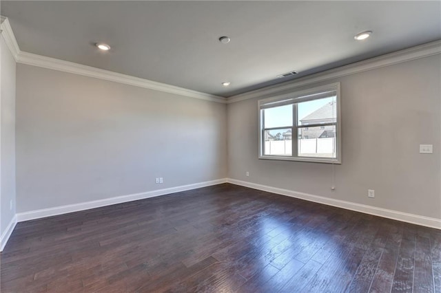 unfurnished room featuring baseboards, dark wood-style flooring, visible vents, and crown molding