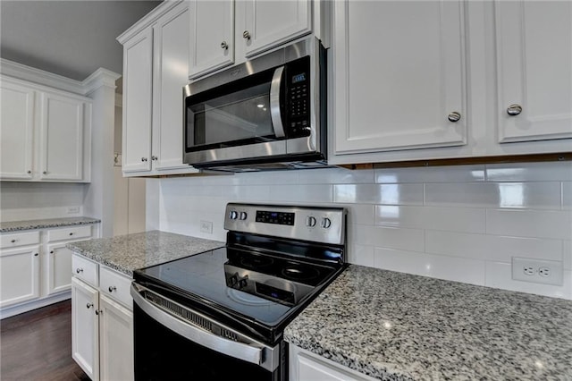 kitchen with dark wood-style floors, white cabinets, backsplash, electric range oven, and stainless steel microwave