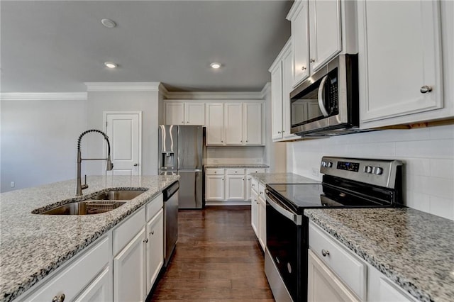 kitchen featuring dark wood finished floors, crown molding, appliances with stainless steel finishes, white cabinetry, and a sink