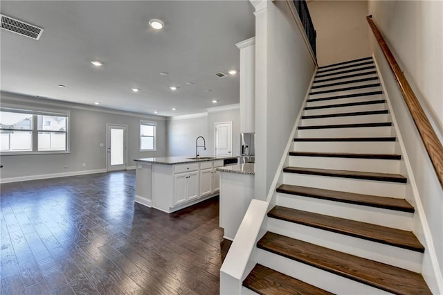 staircase with baseboards, visible vents, wood finished floors, crown molding, and recessed lighting