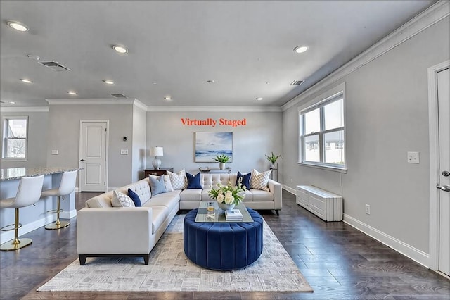 living room featuring ornamental molding, visible vents, baseboards, and wood finished floors