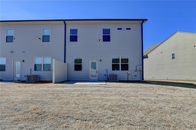 back of property featuring central AC unit and a lawn