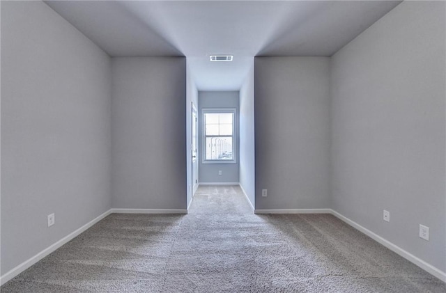 carpeted empty room featuring visible vents and baseboards