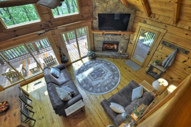 28452 Morganton Hwy, Suches, GA 30572 - living room with wood-type flooring, a stone fireplace, high vaulted ceiling, wooden ceiling with exposed beams, and wood walls