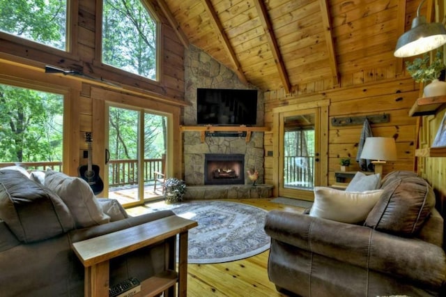 28452 Morganton Hwy, Suches, GA 30572 - living area featuring wood ceiling with exposed beams, plenty of natural light, high vaulted ceiling, wooden walls, and a stone fireplace