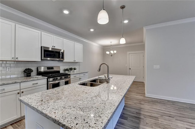 kitchen featuring white cabinetry, a kitchen island with sink, pendant lighting, and stainless steel appliances