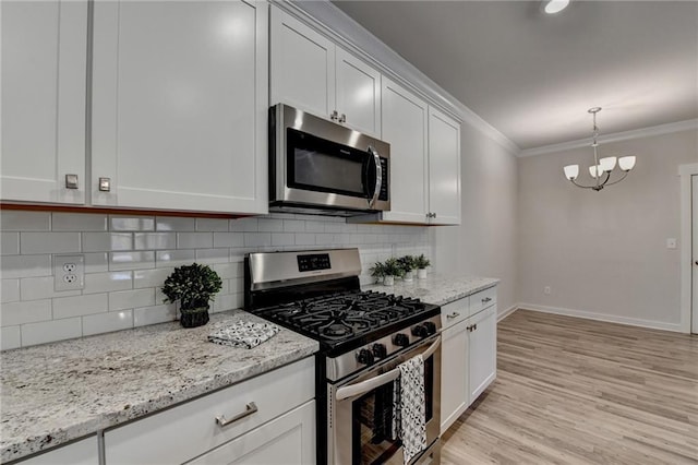 kitchen featuring an inviting chandelier, crown molding, light hardwood / wood-style floors, white cabinets, and appliances with stainless steel finishes