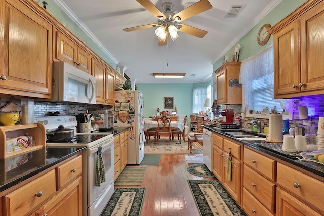 kitchen with tasteful backsplash, light hardwood / wood-style flooring, crown molding, sink, and white appliances