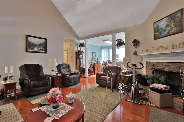 living room with a stone fireplace, high vaulted ceiling, and light hardwood / wood-style floors