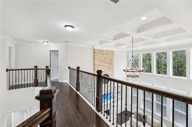 corridor with crown molding, coffered ceiling, dark hardwood / wood-style flooring, and a chandelier