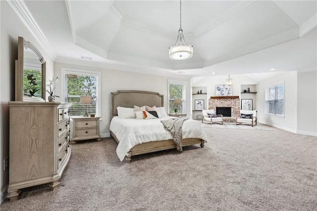 carpeted bedroom with crown molding, a fireplace, and a tray ceiling