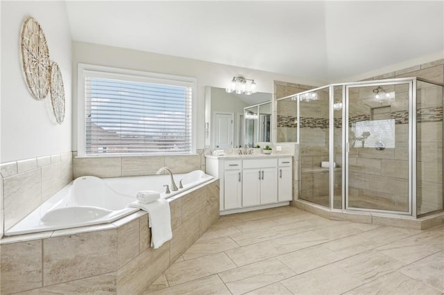 bathroom with vanity, vaulted ceiling, and independent shower and bath