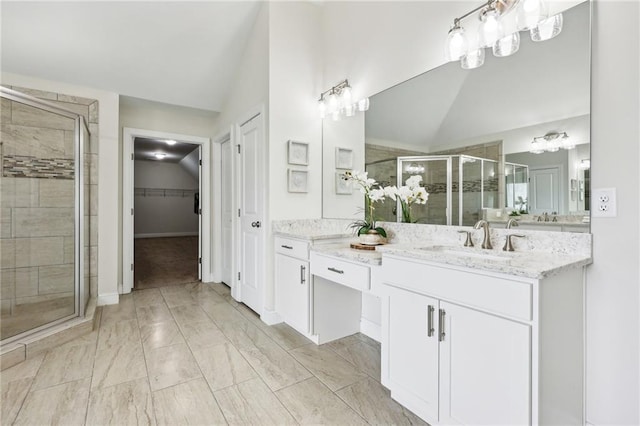 bathroom with lofted ceiling, vanity, and a shower with door