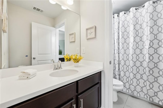 bathroom featuring vanity, toilet, and tile patterned flooring