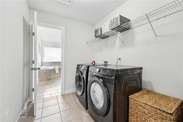 laundry area featuring washing machine and clothes dryer and light tile patterned floors