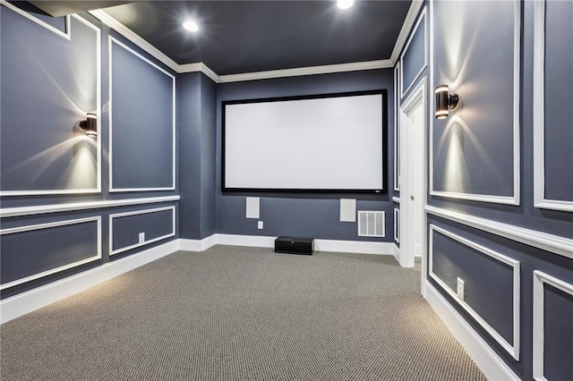 carpeted home theater featuring crown molding