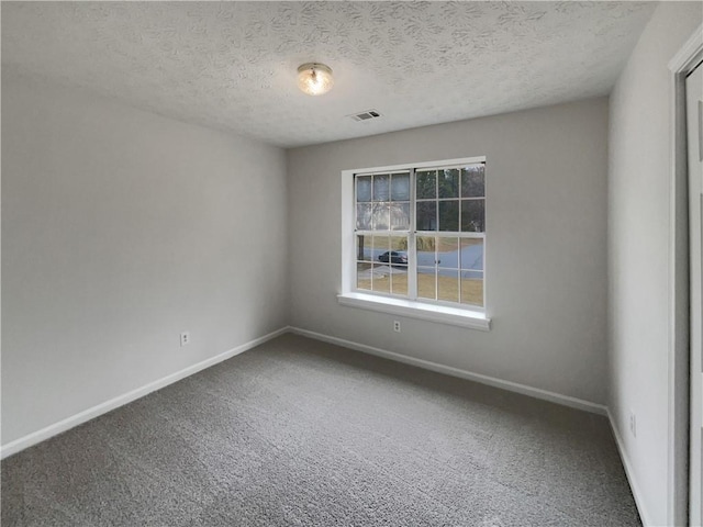 carpeted empty room with baseboards, visible vents, and a textured ceiling