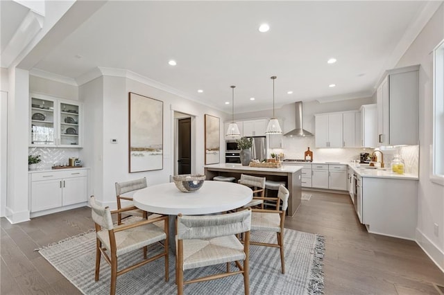 dining space featuring ornamental molding, recessed lighting, wood finished floors, and baseboards