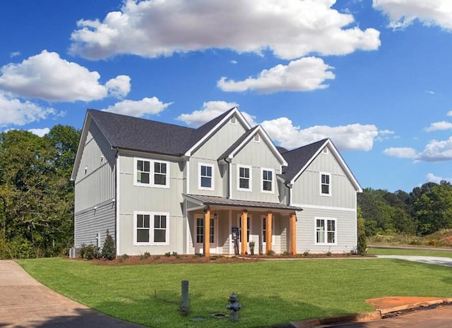 view of front facade with a standing seam roof, a porch, a front yard, and metal roof