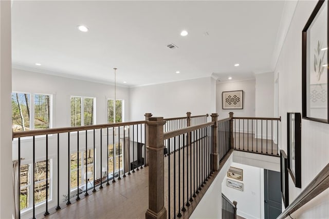 hall with ornamental molding, recessed lighting, and an upstairs landing