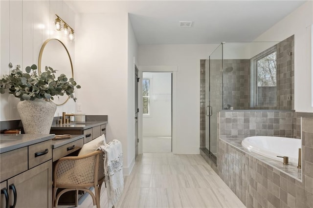 bathroom with a shower stall, a bath, vanity, baseboards, and visible vents