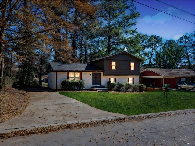 tri-level home featuring a garage and a front lawn