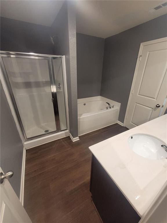 bathroom featuring hardwood / wood-style flooring, vanity, and separate shower and tub