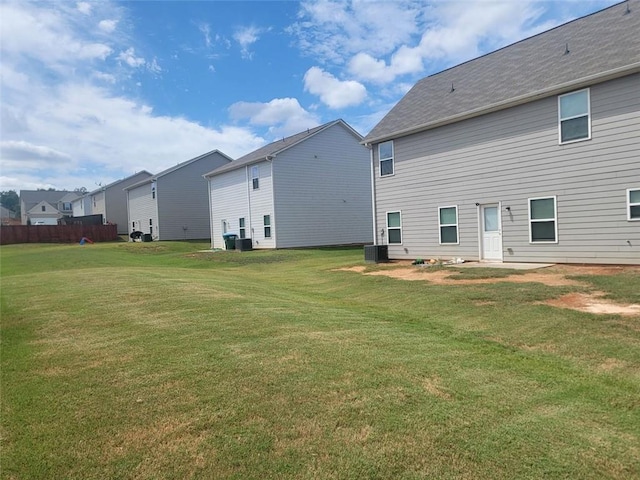 back of property with a lawn and central air condition unit