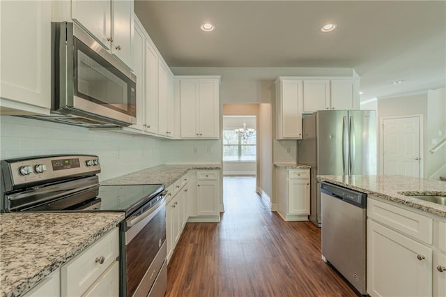 392 Dublin Way, Dallas, GA 30132 - kitchen featuring dark wood finished floors, white cabinets, backsplash, and appliances with stainless steel finishes