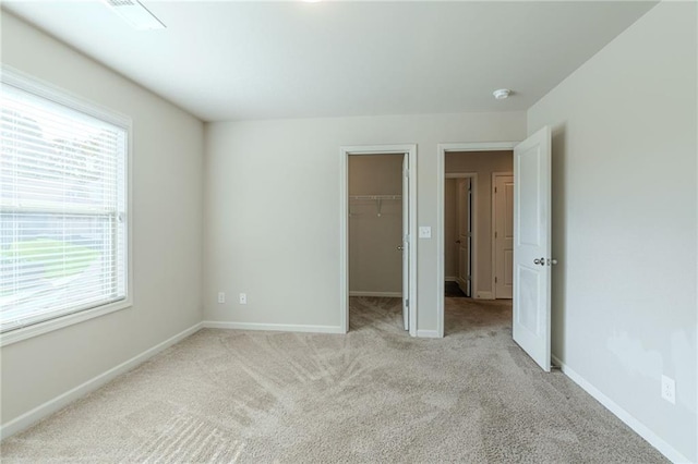 392 Dublin Way, Dallas, GA 30132 - unfurnished bedroom featuring multiple windows, baseboards, light colored carpet, and a spacious closet