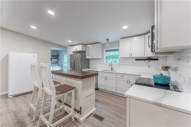 67 Gatewood Rd, Ellijay, GA 30540 - kitchen featuring appliances with stainless steel finishes, a sink, light wood-style flooring, a breakfast bar, and recessed lighting