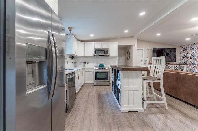67 Gatewood Rd, Ellijay, GA 30540 - kitchen featuring stainless steel appliances, lofted ceiling, light wood finished floors, a sink, and white cabinets