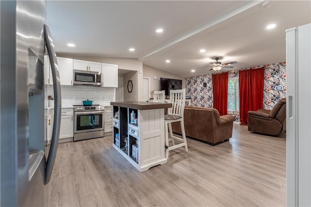 67 Gatewood Rd, Ellijay, GA 30540 - kitchen featuring stainless steel appliances, wallpapered walls, open floor plan, white cabinets, and a breakfast bar