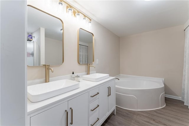 67 Gatewood Rd, Ellijay, GA 30540 - bathroom featuring double vanity, a garden tub, and wood finished floors