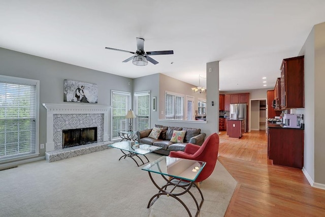 1663 Willow Way, Woodstock, GA 30188 - living room with light wood-type flooring, ceiling fan, a high end fireplace, baseboards, and a chandelier