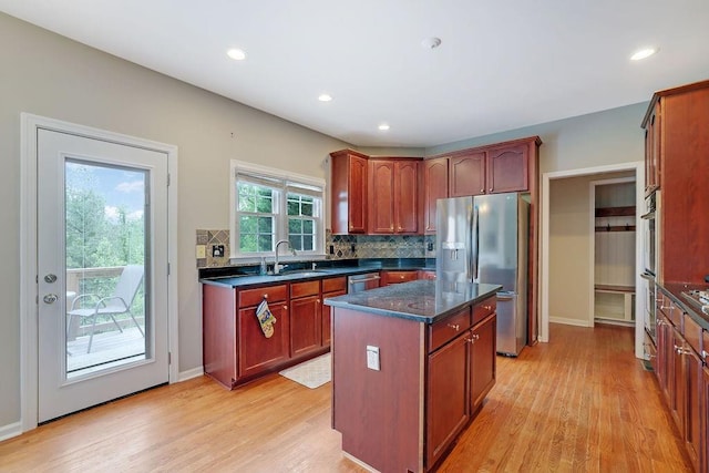 1663 Willow Way, Woodstock, GA 30188 - kitchen with stainless steel appliances, a sink, tasteful backsplash, light wood-type flooring, and a kitchen island