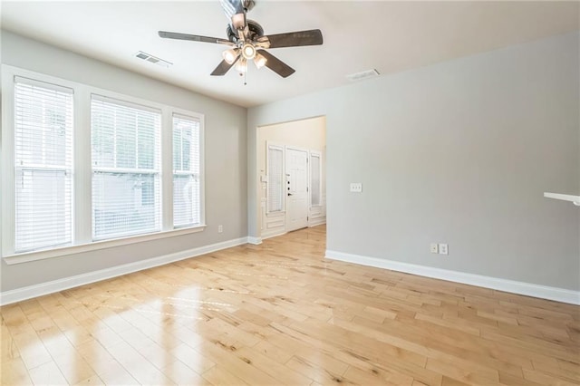 spare room featuring ceiling fan, baseboards, visible vents, and light wood-type flooring