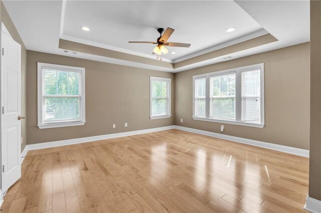 unfurnished room with crown molding, a tray ceiling, and visible vents